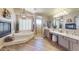 Bright bathroom featuring a soaking tub, a walk-in shower, dual vanities, and two fireplaces at 7424 E Sandia Cir, Mesa, AZ 85207