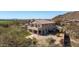View of the property's exterior with a tile roof, covered patio, and desert landscaping; golf course in background at 7424 E Sandia Cir, Mesa, AZ 85207