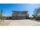 Two-story home featuring a three-car garage, desert landscaping, and modern design elements at 7424 E Sandia Cir, Mesa, AZ 85207