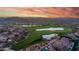 Stunning aerial view of a lush green golf course with scenic water features nestled among luxury homes at sunset at 7424 E Sandia Cir, Mesa, AZ 85207
