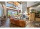 Spacious living room with a stone fireplace, large windows, and leather furniture for luxurious comfort at 7424 E Sandia Cir, Mesa, AZ 85207