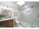 Bright bathroom featuring a glass shower with a seat, a skylight, and a modern vanity at 7801 N 4Th Pl, Phoenix, AZ 85020