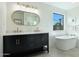 Bathroom featuring modern tub, black vanity with double sinks and gold accents at 7801 N 4Th Pl, Phoenix, AZ 85020