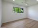 Minimalist bedroom with hardwood floors, white walls, and a large window at 7801 N 4Th Pl, Phoenix, AZ 85020