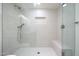 Modern glass shower stall featuring a seat, a built-in shelf, and light gray tiled walls at 7801 N 4Th Pl, Phoenix, AZ 85020