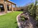 Lush artificial turf extends from a covered patio, alongside a landscaped garden with rocks and flowers at 7955 E Chaparral Rd # 34, Scottsdale, AZ 85250