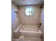 Stylish bathroom with a soaking tub, a round window, a built in bench, and a shower head at 7955 E Chaparral Rd # 34, Scottsdale, AZ 85250