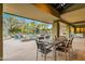 Spacious covered back patio with stone floors, dining table, and views of the pool and desert landscaping at 8724 N 68Th St, Paradise Valley, AZ 85253