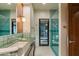 Bright bathroom featuring a large mirror, vanity with green marble countertop, and a glass-enclosed shower at 8724 N 68Th St, Paradise Valley, AZ 85253