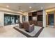 Inviting living room with stone floors, leather seating, built-in shelves, and a view of the patio at 8724 N 68Th St, Paradise Valley, AZ 85253