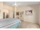 Bright bedroom with carpet, ceiling fan, ensuite bathroom, and dresser at 8850 W Piute Ave, Peoria, AZ 85382