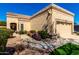 A charming home with a tan exterior, well-kept landscaping, and a two-car garage at 8850 W Piute Ave, Peoria, AZ 85382