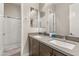 Contemporary bathroom featuring double sinks with sleek countertops, modern fixtures, and a glass-enclosed shower at 10431 E Tiger Lily Ave, Mesa, AZ 85212