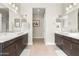 Spacious bathroom with dual vanities, white countertops, and dark wood cabinets and large mirrors at 10431 E Tiger Lily Ave, Mesa, AZ 85212