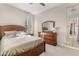 Warm bedroom featuring a wooden bed, a matching dresser, a mirror, and soft lighting, creating an inviting atmosphere at 10431 E Tiger Lily Ave, Mesa, AZ 85212