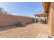 Low-maintenance backyard with gravel landscaping, covered patio, and privacy fencing, perfect for outdoor relaxation at 11121 E Onza Ave, Mesa, AZ 85212