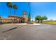 A view of the community clubhouse entrance with manicured landscape and palm trees on a clear sunny day at 11121 E Onza Ave, Mesa, AZ 85212