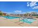 Outdoor community pool with lounge chairs, tables, umbrellas and a connected jacuzzi tub at 11121 E Onza Ave, Mesa, AZ 85212