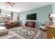 Cozy living room with brown sofa, large rug, and television at 11121 E Onza Ave, Mesa, AZ 85212