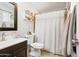 This bathroom includes a vanity, toilet, and shower with neutral tones and decorative shelving at 11446 W Hidalgo Ave, Tolleson, AZ 85353