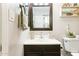 Bright bathroom features a vanity with framed mirror, decorative shelf, and tiled flooring at 11446 W Hidalgo Ave, Tolleson, AZ 85353