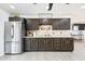 Well-lit kitchen with stainless steel refrigerator, dark wood cabinets, and a clean, functional design at 11446 W Hidalgo Ave, Tolleson, AZ 85353