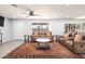 Bright living room featuring a ceiling fan, expansive windows, and elegant furniture arrangement at 11446 W Hidalgo Ave, Tolleson, AZ 85353