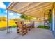 Covered patio with string lights and wooden furniture, offering a cozy and stylish outdoor living area at 11446 W Hidalgo Ave, Tolleson, AZ 85353