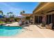 Expansive backyard with a refreshing swimming pool, outdoor kitchen, and mature palm trees at 15385 W Indianola Ave, Goodyear, AZ 85395