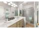 Bright bathroom with double sinks, framed mirrors, and a glass-enclosed shower at 15385 W Indianola Ave, Goodyear, AZ 85395