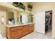 Elegant bathroom with double vanity, granite counters, and walk-in closet at 15385 W Indianola Ave, Goodyear, AZ 85395