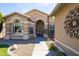 Charming front exterior with an arched entryway, desert landscaping, and decorative wrought iron accent at 15385 W Indianola Ave, Goodyear, AZ 85395