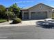 Two-car garage featuring neutral paint, decorative windows, and well-maintained landscaping in a suburban neighborhood at 15385 W Indianola Ave, Goodyear, AZ 85395