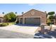 Spacious three-car garage with a wide driveway, mature landscaping, and a well-maintained exterior at 15385 W Indianola Ave, Goodyear, AZ 85395