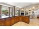 Kitchen island with dark countertops and wood cabinetry, pool view at 15385 W Indianola Ave, Goodyear, AZ 85395