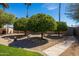 Well-manicured landscaping with mature trees, gravel beds, and a charming pathway at 15385 W Indianola Ave, Goodyear, AZ 85395