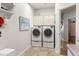 Convenient laundry room featuring a washer, dryer, and built-in storage cabinets at 15385 W Indianola Ave, Goodyear, AZ 85395