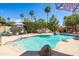 Inviting pool area with rock features, lounging chairs, landscaping and shaded areas in a backyard at 15385 W Indianola Ave, Goodyear, AZ 85395