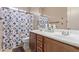 Bathroom showcases a double sink vanity, a toilet, and a shower with a blue patterned curtain at 17743 W Verdin Rd, Goodyear, AZ 85338