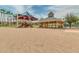 Sandy community area featuring a playground, shaded pavilions, and lush palm trees at 17743 W Verdin Rd, Goodyear, AZ 85338