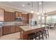 Modern kitchen with island seating, stainless steel appliances, and dark wood cabinets at 17743 W Verdin Rd, Goodyear, AZ 85338