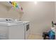 Laundry room with washer, dryer, storage shelf, and ceramic tile flooring at 17743 W Verdin Rd, Goodyear, AZ 85338