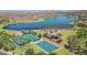 Overhead view of tennis and basketball courts near the lake, a sandy beach area, and a playground at 17893 W Indigo Brush Rd, Goodyear, AZ 85338