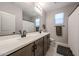 Modern bathroom with double sinks, light wood cabinets, and a large mirror, offering a clean aesthetic at 17893 W Indigo Brush Rd, Goodyear, AZ 85338