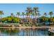 Beautiful community clubhouse with palm trees lining the water and lush landscaping at 17893 W Indigo Brush Rd, Goodyear, AZ 85338