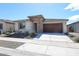 Charming single-story home featuring stone accents, a two-car garage, and low maintenance desert landscaping at 17893 W Indigo Brush Rd, Goodyear, AZ 85338