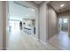 Bright hallway with wood-look tile flooring leading to an open kitchen and living area at 17893 W Indigo Brush Rd, Goodyear, AZ 85338