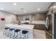 Modern kitchen features stainless steel appliances, a large island with seating, and ample cabinet space at 17893 W Indigo Brush Rd, Goodyear, AZ 85338