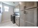 This laundry room features grey shaker cabinets, a white countertop, a front-loading washer and dryer, and tile flooring at 17893 W Indigo Brush Rd, Goodyear, AZ 85338