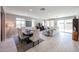 Spacious living room features a dining area, modern decor, and plenty of natural light from large windows at 17893 W Indigo Brush Rd, Goodyear, AZ 85338